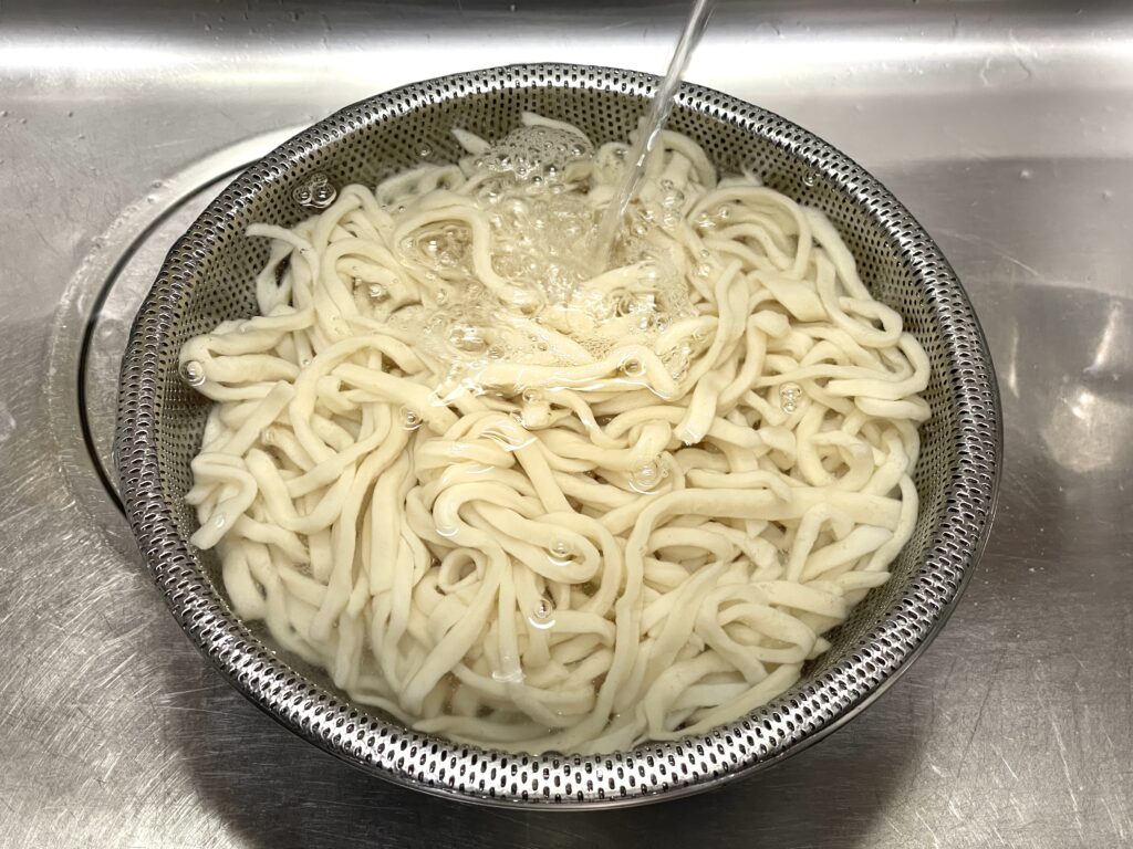 茹でたうどんのを洗い、滑りをとる