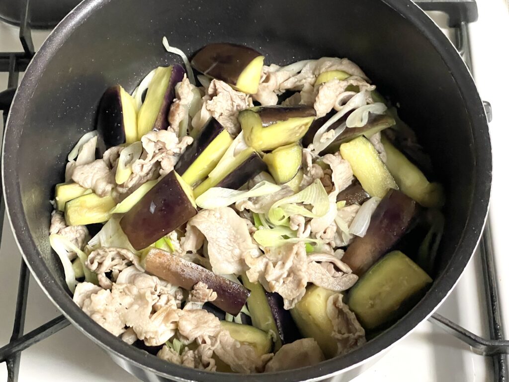豚コマ肉となす、長ネギを炒める