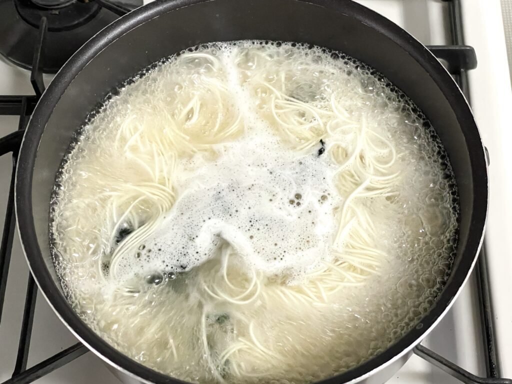 鶏がらスープにそうめんとカットわかめを入れて茹でる