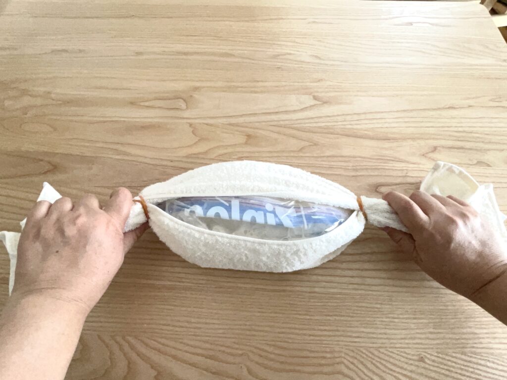 アイスクリームを作る袋を、タオルに包み輪ゴムで止め、揺する。